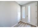 Bright entryway featuring a white door with glass inserts and light wood-look flooring, leading into the home at 8629 Ensworth St # 113, Las Vegas, NV 89123