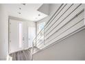 Bright hallway with modern railing leading upstairs and a sleek door with a glass insert at 8629 Ensworth St # 113, Las Vegas, NV 89123