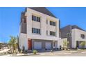 Modern home featuring two-car garage, bright red door, and a small balcony at 8629 Ensworth St # 114, Las Vegas, NV 89123