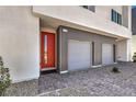 Contemporary home exterior showcasing brick paved driveway leading to a red front door and a two-car garage at 8629 Ensworth St # 114, Las Vegas, NV 89123