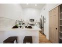Bright kitchen featuring white cabinets, stainless steel appliances, and a convenient breakfast bar area at 10229 Birch Bluff Ln, Las Vegas, NV 89145