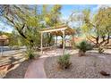 Landscaped courtyard features a pergola, walkway, and rock garden at 10548 Findlay Ave, Las Vegas, NV 89134
