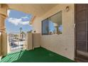 Private condo patio with secure gate, artificial turf, and view of parking area at 1333 Pinto Rock Ln # 202, Las Vegas, NV 89128