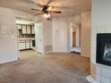 Open-concept living room featuring a fireplace, ceiling fan, and a view into the adjoining kitchen at 1904 Las Palmas Ln # 101, Laughlin, NV 89029