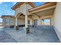 Inviting covered front entry with decorative columns, stone accents, and a modern front door at 3080 S Prairie Ave, Pahrump, NV 89048