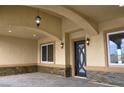 Inviting front porch with decorative stone accents, elegant lighting, and a stylish front door at 3080 S Prairie Ave, Pahrump, NV 89048