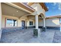 Spacious front porch featuring stone columns, stylish lighting, and a modern front door at 3080 S Prairie Ave, Pahrump, NV 89048