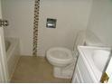 Small bathroom with tiled walls, tile flooring, and a standard toilet, sink and tub at 313 View Dr, Las Vegas, NV 89107
