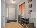 Inviting entryway with neutral walls, displaying artwork, a tiled floor, and a convenient shelving unit at 3785 Corpolo Ave, Las Vegas, NV 89141