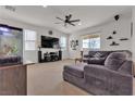 Spacious living room features a ceiling fan, neutral carpet, and a comfortable gray sectional sofa at 4211 Enchanting Sky Ave, North Las Vegas, NV 89081