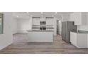 Open concept kitchen with a central island, stainless steel appliances, and hardwood floors at 4244 Golden Sol St, North Las Vegas, NV 89032