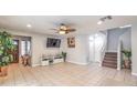Spacious living room with neutral tile flooring, recessed lighting, and an inviting open layout with staircase at 5032 Dancing Lights Ave, Las Vegas, NV 89130