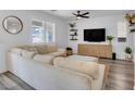 Bright living room with hardwood floors, a modern ceiling fan, and neutral decor at 7023 Amethyst Peak St, Las Vegas, NV 89148