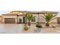 Well-maintained home exterior with desert landscaping, two-car garage, and front yard at 7682 Rafter Ct, Las Vegas, NV 89139