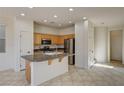 Bright kitchen with stainless steel appliances, light wood cabinets, and tile flooring at 9013 Semillon St, Las Vegas, NV 89148