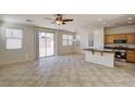 Open-concept living room with tile flooring, recessed lighting, and sliding glass doors to the backyard at 9013 Semillon St, Las Vegas, NV 89148