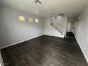 Open-concept living room features hardwood floors and staircase, offering a seamless flow throughout at 9592 Villa Calera Ave, Las Vegas, NV 89148