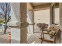 Cozy front porch with rocking chairs, textured columns, and a view of the landscaped yard at 9844 Altadena St, Las Vegas, NV 89183