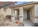 Inviting front porch with decorative columns, seating area, and well-maintained landscaping at 9844 Altadena St, Las Vegas, NV 89183