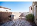 Backyard with desert landscaping, stone patio, brick walls and an outdoor grill at 9906 Fife Lake Ct, Las Vegas, NV 89148