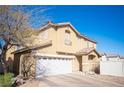Two-story home with a tile roof and stucco exterior, showcasing a two-car garage and desert landscaping at 9906 Fife Lake Ct, Las Vegas, NV 89148