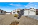 Exterior shot of home with desert landscaping and three car garage with blue sky at 1006 Christopher View Ave, North Las Vegas, NV 89032