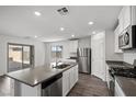 Bright open kitchen with stainless appliances, gray stone countertops, and sliding door access to patio at 1709 Desert Path Ave, North Las Vegas, NV 89032