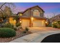 Two-story home featuring a three-car garage, well-maintained landscaping, and warm exterior lighting at 1801 Glory Creek Dr, Las Vegas, NV 89128