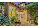 Inviting front entrance with a blue door, brick walkway, and lush greenery and rock landscape at 1801 Glory Creek Dr, Las Vegas, NV 89128
