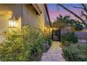 Landscaped side yard with a stone path leading to a gated entrance, providing privacy and charm at 1801 Glory Creek Dr, Las Vegas, NV 89128