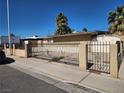 Street view of single-story home featuring desert landscaping, and an ornate wrought iron gate at 2746 E Owens Ave, North Las Vegas, NV 89030