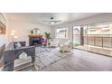 Cozy living room featuring modern decor, a fireplace, a ceiling fan, and a sliding door to the outside at 2834 Natalie Ave, Las Vegas, NV 89121