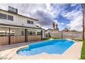 A backyard pool with a modern fence design, an overhang, and blue skies with picturesque clouds at 2834 Natalie Ave, Las Vegas, NV 89121