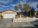 Inviting single-story house with attached garage, mature tree, and a cute white picket fence at 3572 Tempe St, Las Vegas, NV 89103