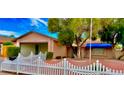 Inviting single-story home featuring a neatly kept yard with a classic white picket fence and mature trees at 3572 Tempe St, Las Vegas, NV 89103