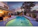 Inviting backyard showcasing a sparkling pool, spa, covered patio, and lush landscaping, perfect for outdoor relaxation at 37 Stone Cress Dr, Henderson, NV 89074