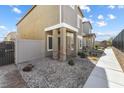 Property featuring a front porch with stately columns, xeriscaping, and neutral stucco exterior at 4371 Fire Glow Ave, North Las Vegas, NV 89084