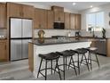 Stylish kitchen with an island featuring seating, modern appliances, and dark countertops with light colored cabinets at 5766 Remy Rain St, Las Vegas, NV 89148