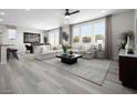 Bright living room with modern decor, neutral color palette, and large windows offering plenty of natural light at 5766 Remy Rain St, Las Vegas, NV 89148