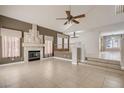 Bright living room featuring neutral tile flooring, fireplace, large windows, and an airy open floor plan at 7228 Buglehorn St, Las Vegas, NV 89131