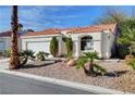 Inviting single-story home with red tile roof, desert landscaping and a two-car garage at 7772 Buckwood Ct, Las Vegas, NV 89149