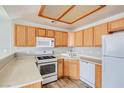 Functional kitchen with white appliances, wooden cabinetry, and a built-in microwave for easy cooking at 9580 W Reno Ave # 211, Las Vegas, NV 89148