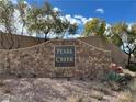 Stone monument marking the entrance to Pearl Creek with lush landscaping and mature trees at 961 Spiracle Ave, Henderson, NV 89002