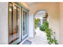Inviting entryway through an arched passageway with views of the home's bright, open courtyard at 10479 Garden Light Dr, Las Vegas, NV 89135