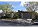 Inviting single-story home showcasing a two-car garage, mature landscaping, and charming curb appeal on a sunny day at 10479 Garden Light Dr, Las Vegas, NV 89135