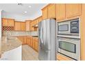 A spacious kitchen featuring stainless steel appliances and wooden cabinetry, blending functionality and elegance at 11298 Merado Peak Dr, Las Vegas, NV 89135