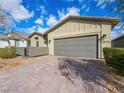 Close up of house exterior featuring a brick driveway and a gray two car garage at 2376 Thelen Ave, North Las Vegas, NV 89086