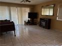 Living room area with tile floors, sliding glass doors and fireplace at 2425 Paradise Village Way, Las Vegas, NV 89120