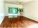 Living room with hardwood floors, ceiling fan, and sliding glass doors to the backyard at 2575 Evening Twilight Ave, Henderson, NV 89044