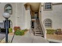 Building exterior with stairs leading to units, featuring stucco, arched windows and landscaping at 3125 N Buffalo Dr # 1105, Las Vegas, NV 89128